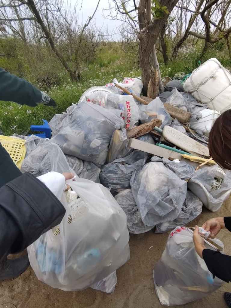 參與者將撿拾的海灘垃圾搬運至集中回收區，展現團隊合作的行動力。